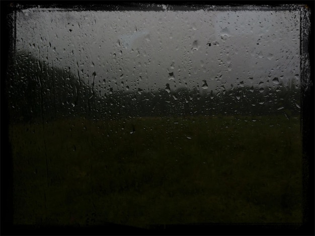 Foto close-up de água de chuva no vidro da janela contra o céu