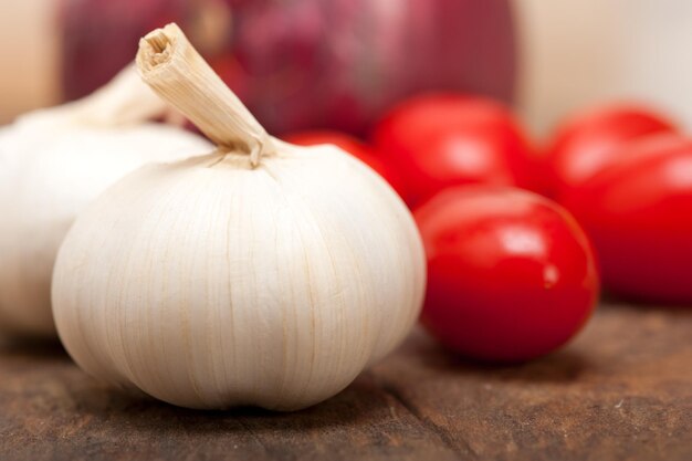 Foto close-up de alho e tomates cereja na mesa