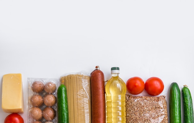 Close-up de alimentos. Legumes, compras, queijo e ovos em um fundo branco