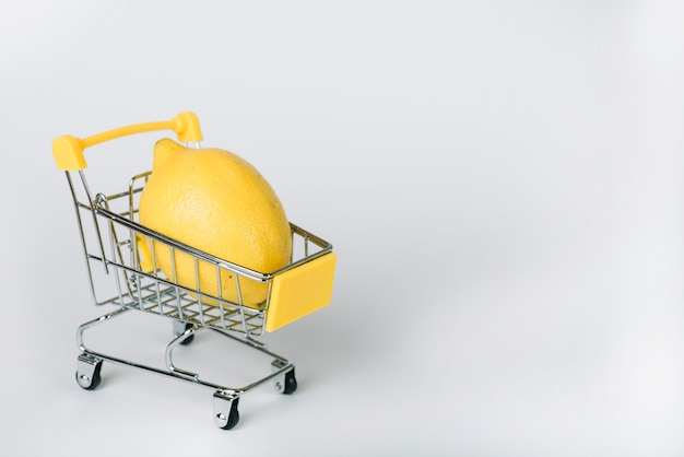 Foto close-up, de, amarela, limão, em, carrinho de compras, branco, fundo