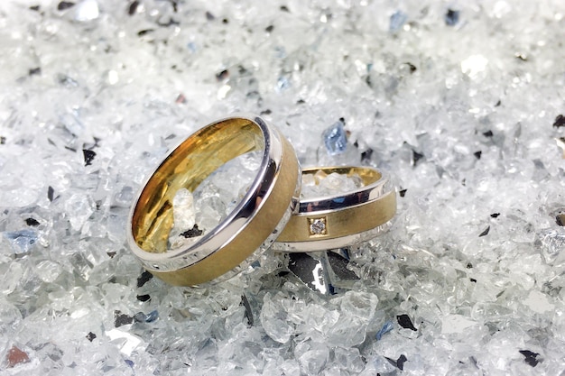 Close-up de anéis de casamento em vidro quebrado