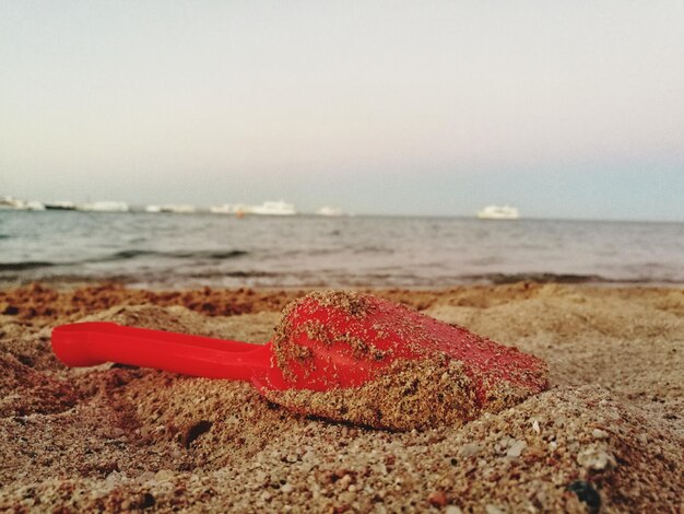 Foto close-up de areia vermelha na praia contra o céu