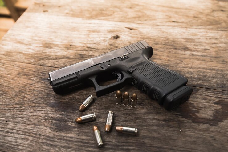 Foto close-up de arma com balas na mesa