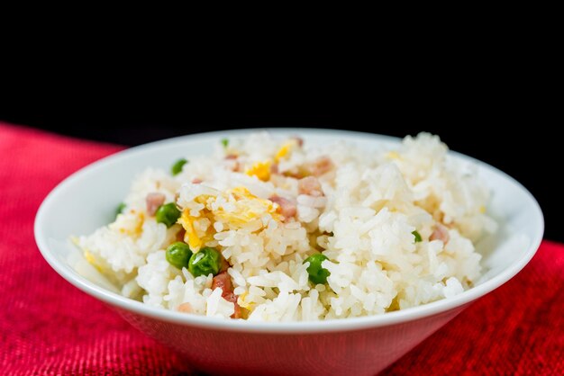 Foto close-up de arroz frito em uma tigela na mesa contra fundo preto