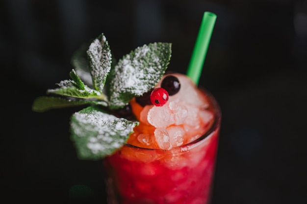 Close-up de bagas de menta e gelo em um mojito de frutas em um bar