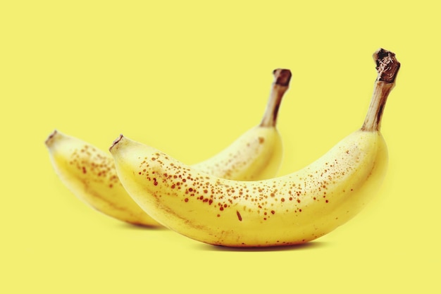 Close-up de bananas amarelas em fundo amarelo