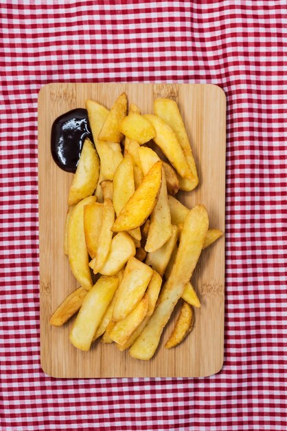 Foto close-up de batatas fritas com molho na mesa