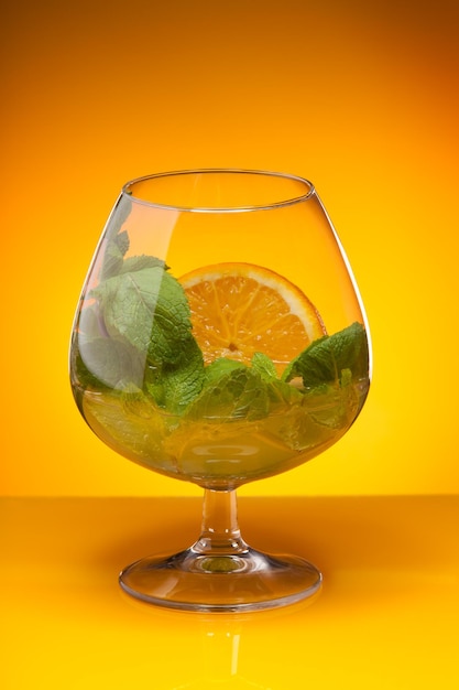 Foto close-up de bebida em copo contra fundo laranja