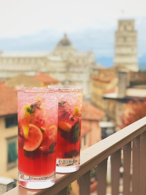 Foto close-up de bebidas servidas em um bar no telhado com vista para a torre de pisa