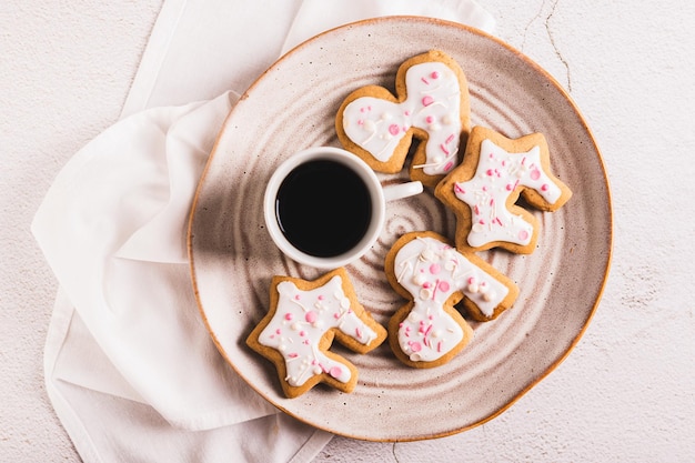 Close-up de biscoitos caseiros abraçando uma caneca de café em um prato na vista da mesa