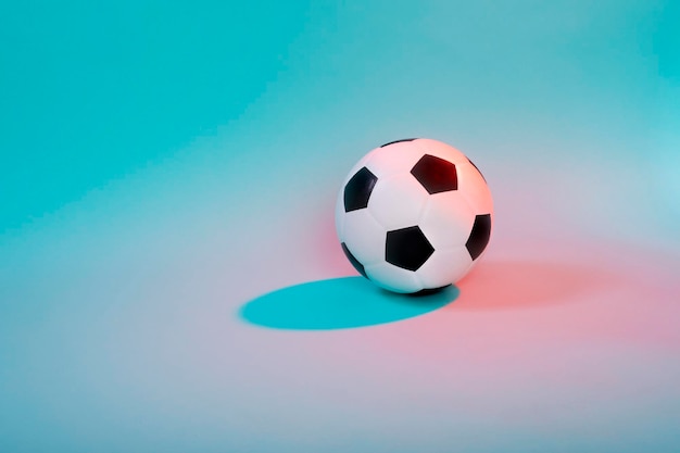Close-up de bola de futebol sobre fundo colorido