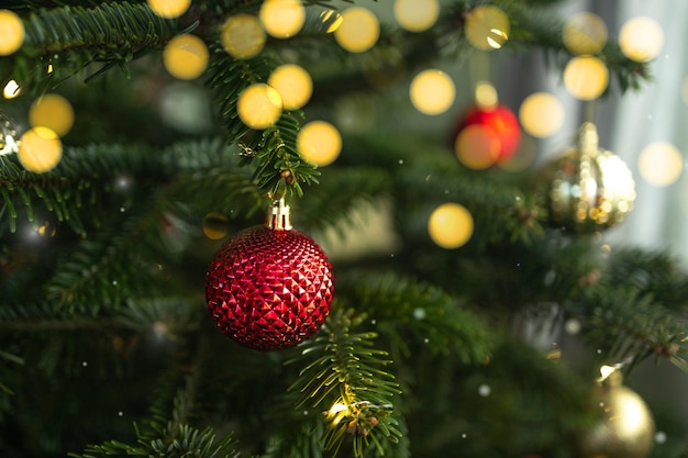 Close-up de bolas de Natal em árvore de Natal bokeh guirlandas no fundo conceito de ano novo alto