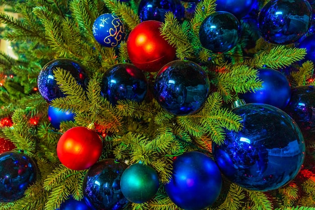 Close-up de bolas em guirlandas de bokeh de árvore de natal no conceito de ano novo de fundo