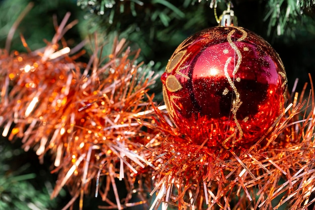 Close-up de bolas na árvore de natal guirlandas bokeh no fundo