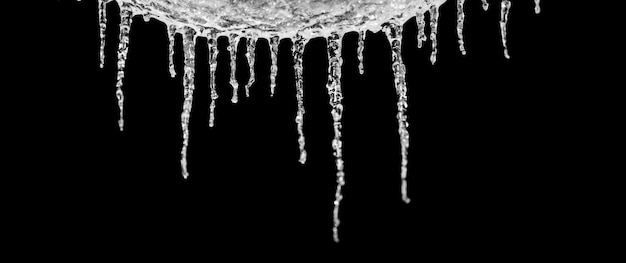 Foto close-up de bolinhos de gelo pendurados contra um fundo preto