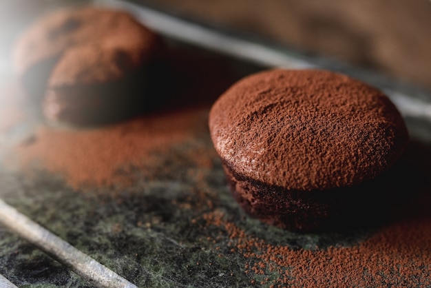 Close up de bolo de chocolate com coração de fondant e cacau em pó como decoração para a sobremesa.