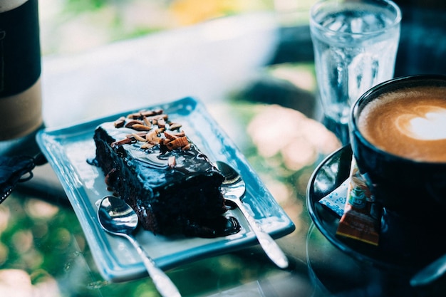 Foto close-up de bolo por xícara de café em prato sobre a mesa