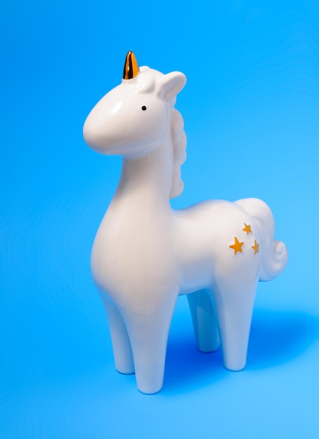 Close-up de brinquedo de unicórnio de pelúcia contra fundo azul