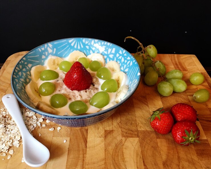 Foto close-up de café da manhã servido em uma tigela com frutas em uma bandeja contra fundo preto