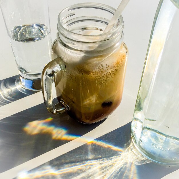 Foto close-up de café gelado em xícara e água potável servida na mesa