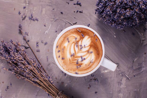 Close up de cappuccino lavanda com creme de leite no copo branco