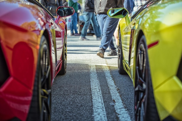 Foto close-up de carros na estrada com pessoas andando no fundo