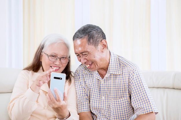 Close-up de casal de velhos sorridentes fazendo uma chamada de vídeo