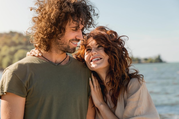 Close-up de casal feliz abraçando e rindo juntos na praia