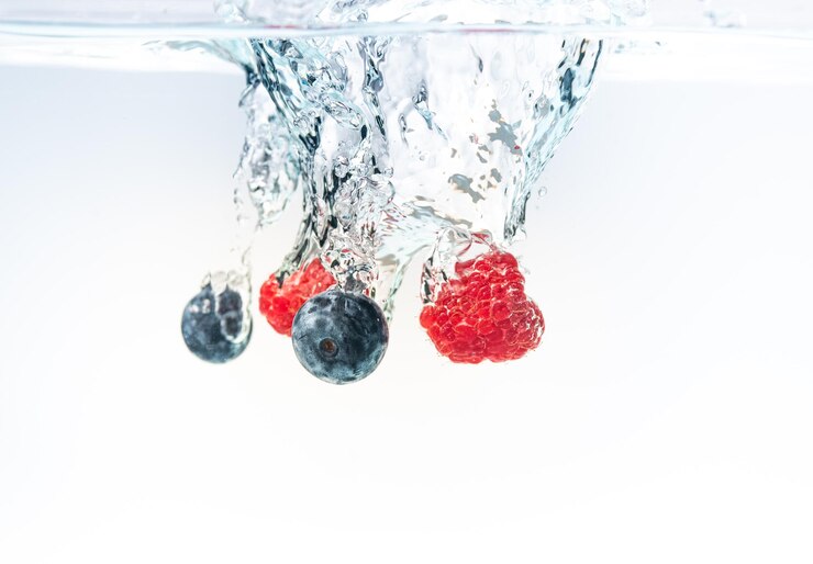 Foto close-up de cerejas na água contra fundo branco