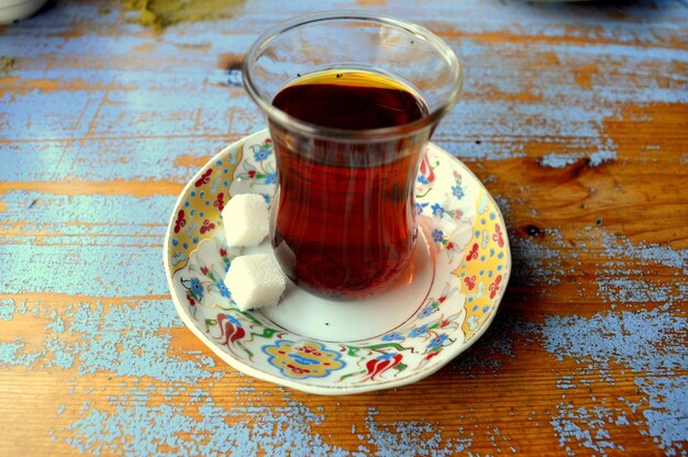 Close-up de chá turco e cubos de gelo em um prato na mesa