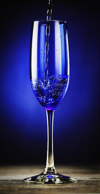Foto close-up de champanhe caindo flauta contra fundo colorido