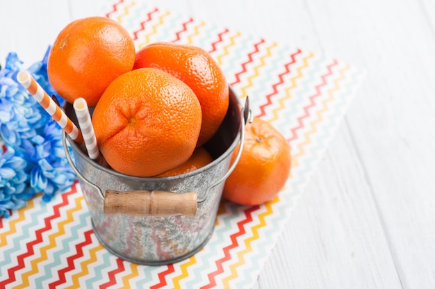 Close-up de clementinas frescas em um balde de lata