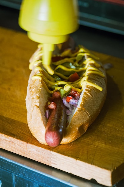 Foto close-up de comida na prancha de cortar cachorro-quente em produção