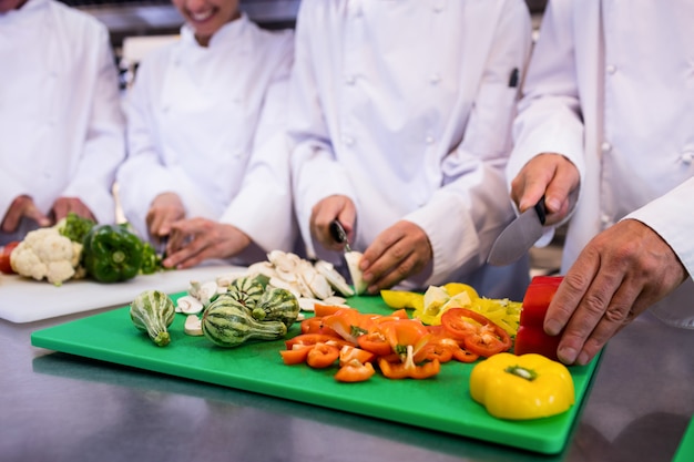 Close-up de cozinheiros chefe cortar legumes