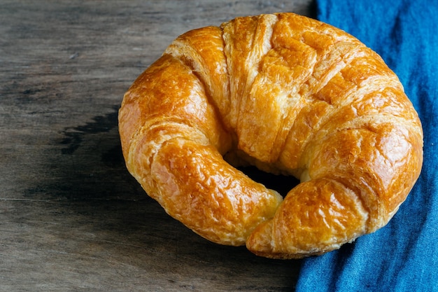 Close-up de croissant por tecido azul na mesa