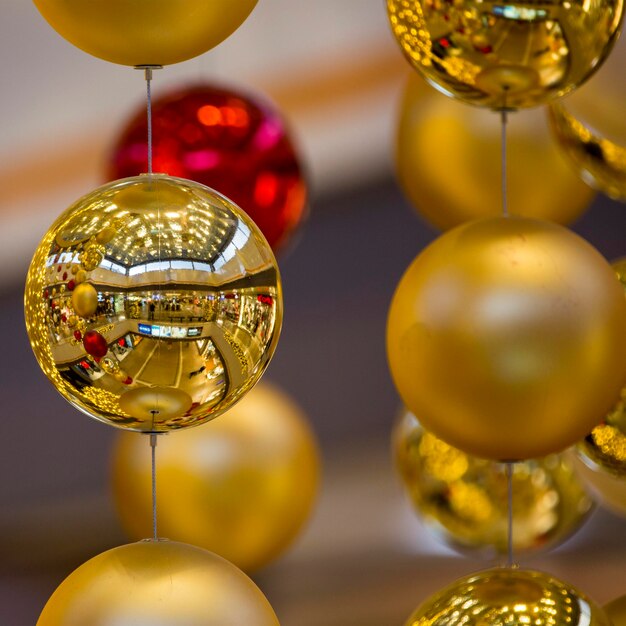 Foto close-up de decorações de bola dourada penduradas no centro comercial