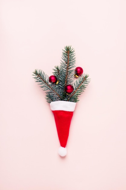 Foto close-up de decorações de natal com chapéu de papai noel em fundo rosa