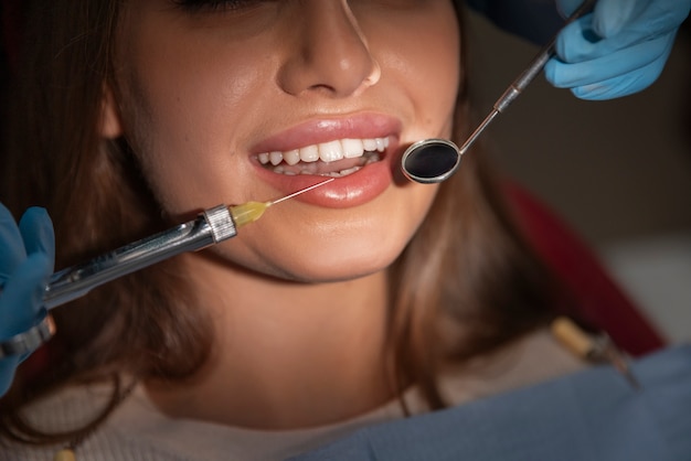 Foto close-up de dentista usando instrumentos