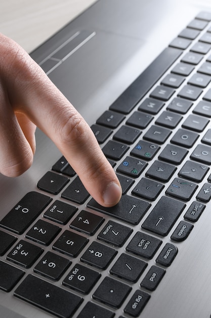 Close-up de digitar no teclado do laptop de mãos masculinas