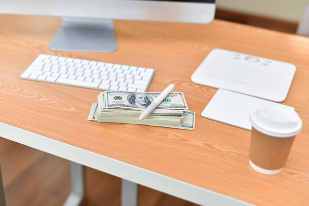 Foto close-up de dinheiro e copo na mesa do escritório
