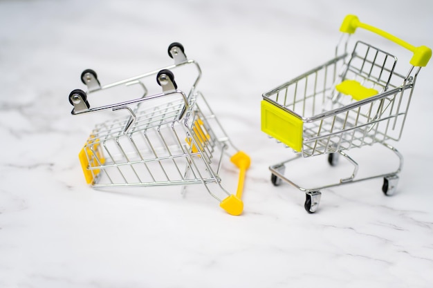 Close up de dois carrinho de compras de brinquedo em miniatura de metal vazio no fundo branco. Compras, supermercado, conceito de venda. Coleção de carrinhos de compras.