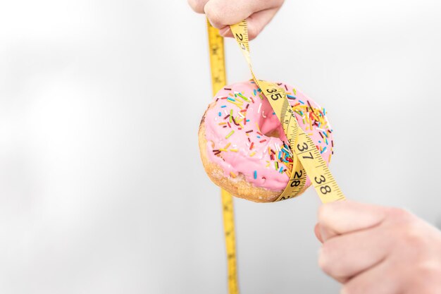 Close up de donut e fita métrica para perda de peso e espaço de cópia do conceito de dieta