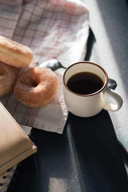 Foto close-up de donuts com café preto e guardanapo na mesa