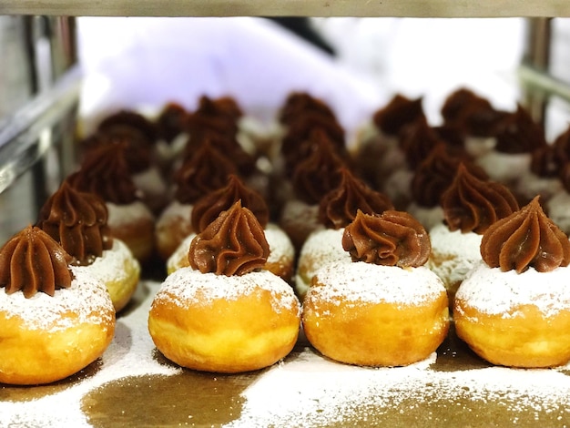 Foto close-up de donuts em bandeja em rack na padaria