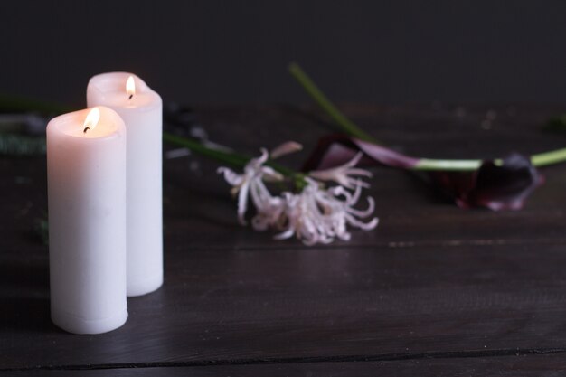 Close-up de duas grandes velas brancas acesas