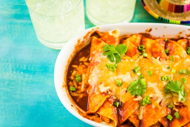 Foto close up de enchiladas de frango caseiras decoradas com cebolinha e coentro.