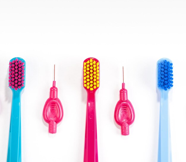 Foto close-up de escovas de dentes coloridas dispostas sobre um fundo branco