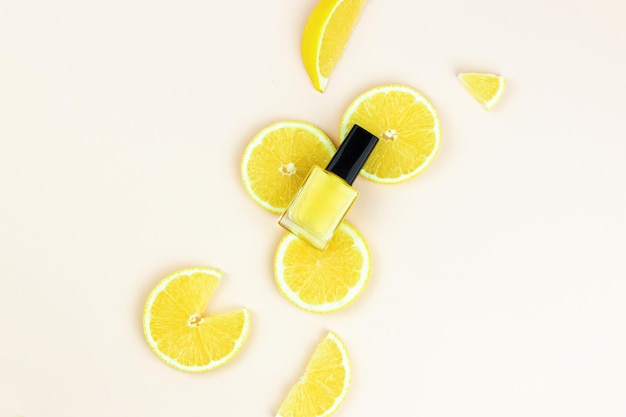 Close-up de esmalte amarelo na mesa com pedaços de limão