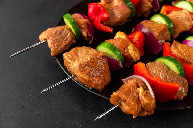 Foto close-up de espigas com carne crua churrasco marinada carne de porco com legumes e especiarias em preto