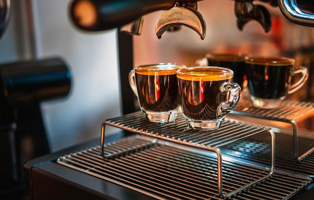 Close-up de espresso filmado com crema de café e máquina de café profissional enquanto prepara dois c